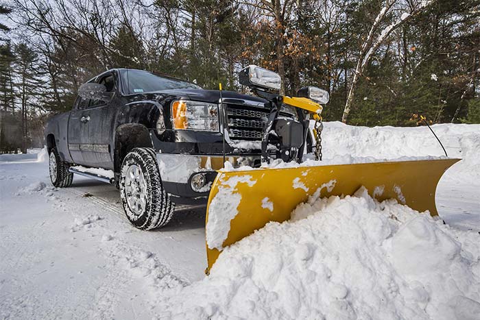 truck pushing snow with an attached snow plower